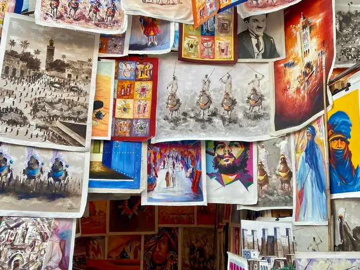 Traditional Moroccan artwork and postcards on display at a Marrakech market stall